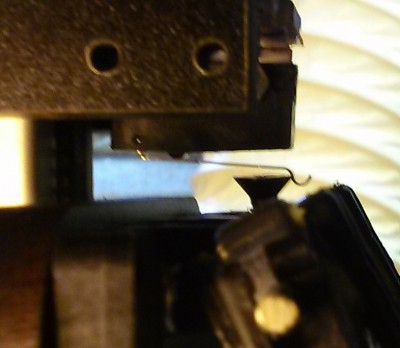 Factory end stop switch lever, installed, with end stop screw precariously on curve of lever